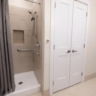 Modern bathroom with a walk-in shower and double doors.
