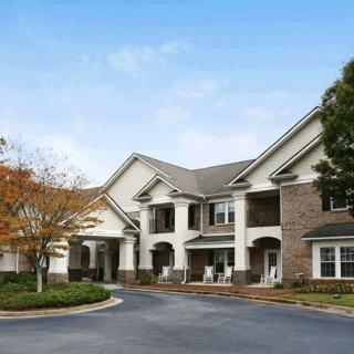 A residential building with a landscaped exterior and trees in the foreground.