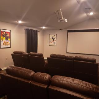A cozy home theater setup with recliner seats and a large projector screen.