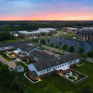 Aerial view of an office park at sunset, featuring multiple buildings surrounded by greenery.