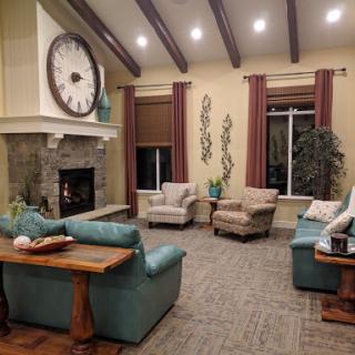 A cozy living room featuring comfortable seating, a stylish fireplace, and decorative elements.
