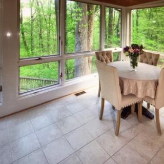 A cozy dining space with a scenic forest view through large windows.