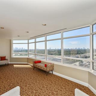 A modern room with large windows offering a cityscape view.