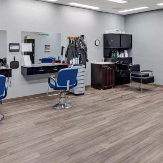 A modern barbershop interior with chairs and mirrors.