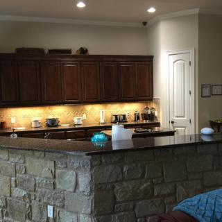 A modern kitchen featuring a stone counter and wooden cabinets.