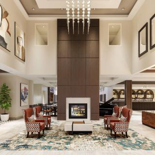 A luxurious hotel lobby with elegant seating and a central fireplace.