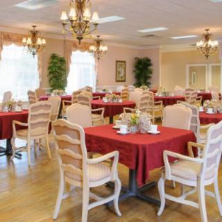 An elegant dining room with red tablecloths and chandeliers.