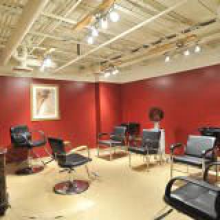 A modern hair salon with red walls and stylish chairs.