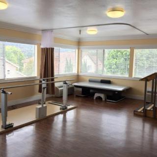 A bright and spacious physical therapy room equipped for rehabilitation exercises.