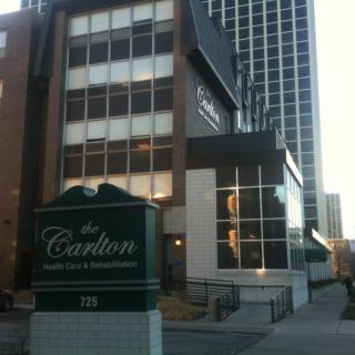 A view of an urban building with signage in front, featuring modern architectural design.