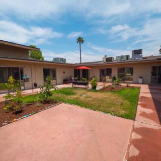 A courtyard with landscaped gardens and a central patio area in an apartment complex.