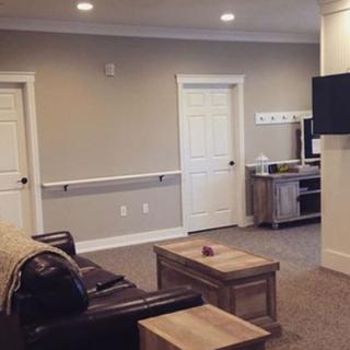 A modern living room with a sofa, television, and coffee table in a neutral color scheme.