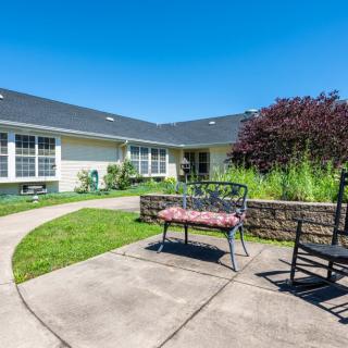 A sunny courtyard with garden seating and a paved pathway.