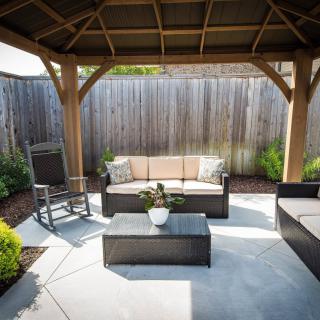 A cozy outdoor patio with comfortable seating under a gazebo.