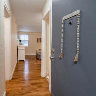 A welcoming hallway with wooden floors and a decorated door.