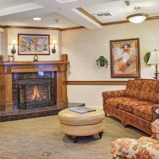 A cozy living room with a fireplace, sofa, and artwork on the walls.