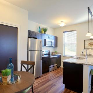 Modern kitchen with stainless steel appliances and wood flooring.