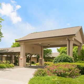 A welcoming entrance to a residential facility surrounded by lush greenery.