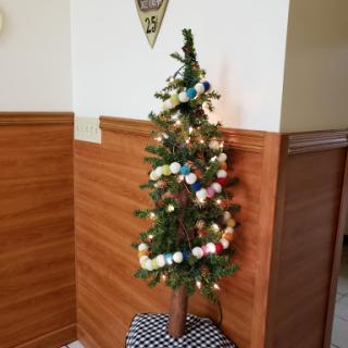 A festive mini Christmas tree adorned with colorful decorations and lights.
