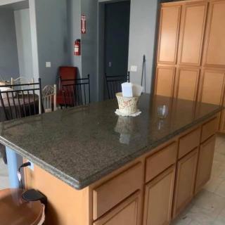 A kitchen with a large island and wooden cabinets.