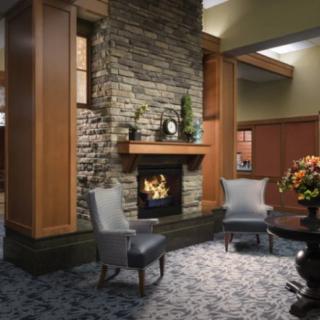 A cozy lobby area featuring a stone fireplace and elegant seating.