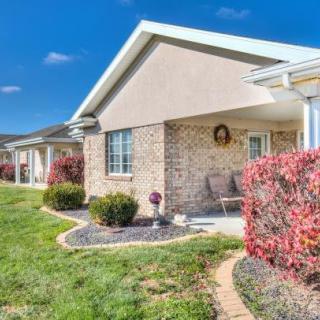 A well-maintained suburban house with a brick exterior and landscaped front yard.