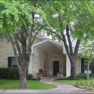 A beautiful home surrounded by lush greenery and a welcoming pathway.