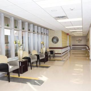 A hospital waiting area with chairs lining the corridor.