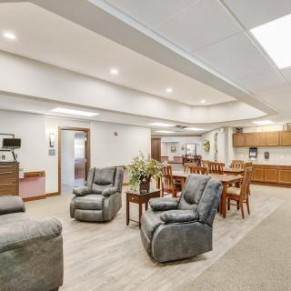A spacious living room with comfortable armchairs and a dining area.