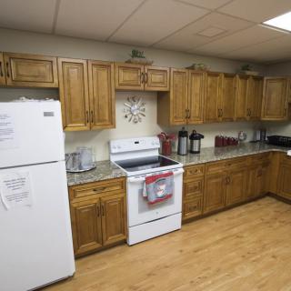 A cozy kitchen with wooden cabinets and modern appliances, including a refrigerator and an oven.