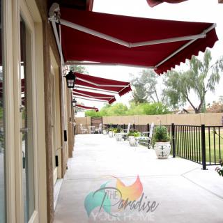 A row of red awnings provides shade along a patio walkway.