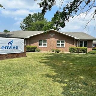 A healthcare facility with a well-maintained lawn and clear signage.