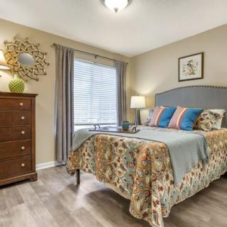 A cozy bedroom with a stylish bed, dresser, and decorative accents.