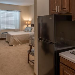 A cozy studio apartment with a kitchenette and a comfortable bedroom area.