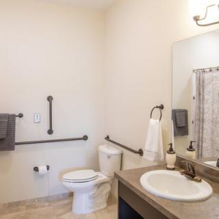 An accessible bathroom with handrails and modern amenities.
