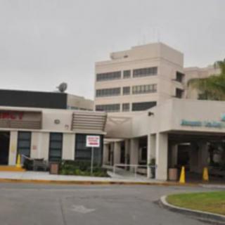 A view of the entrance to a hospital building on a cloudy day.