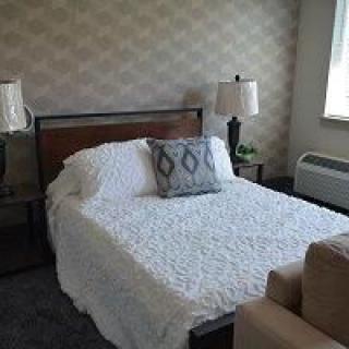 A cozy bedroom with a neatly made bed and stylish decor.