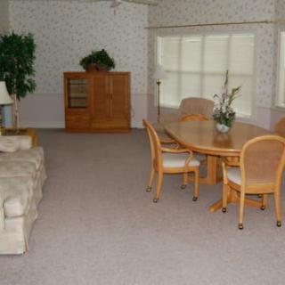Spacious living and dining area with a sofa, dining table, chairs, and a cabinet.