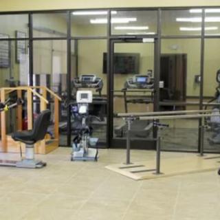A physical therapy room equipped with various rehabilitation machines and tools.