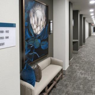A modern hallway with artwork and a seating area.