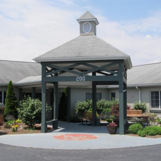 A picturesque building entrance with a gazebo-like structure surrounded by well-maintained landscaping.