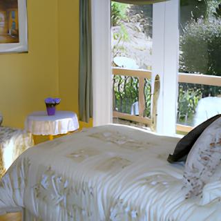 A cozy bedroom with a bed near a large window letting in daylight.
