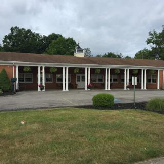 A view of a brick building featuring columns, set against a cloudy sky.
