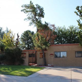 A residential house with a sloped driveway and surrounding trees.