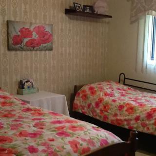 A cozy bedroom with twin beds featuring floral bedspreads and wall decor.