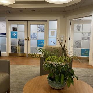 A cozy waiting area featuring a plant and glass-paneled doors.