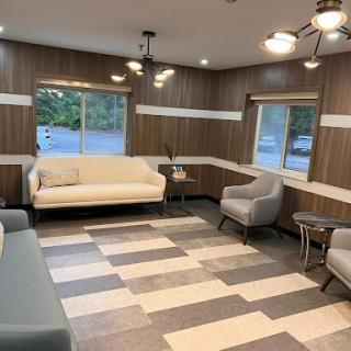 A cozy and modern lounge area featuring a comfortable sofa, stylish chairs, and elegant lighting.