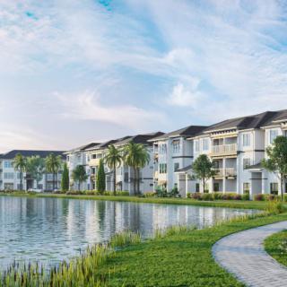 A serene residential area with modern apartments overlooking a lake and a scenic pathway.