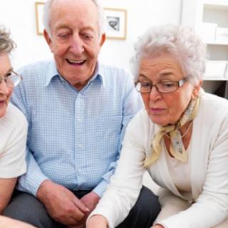 A group of older adults sitting together and enjoying each other's company indoors.