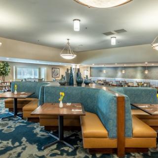 A modern restaurant interior with upholstered booths and stylish lighting fixtures.